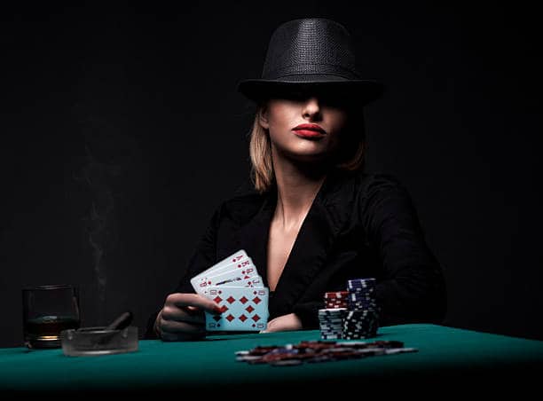 a woman with a hat holding poker cards